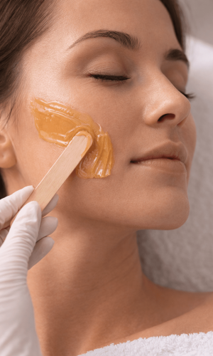 Illustratie van een professional die wax aanbrengt bij de behandeling wangen harsen.